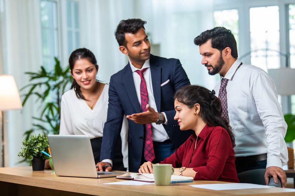 Indian,Asian,Young,Business,Professionals,Using,Laptop,On,Desk,Discussing